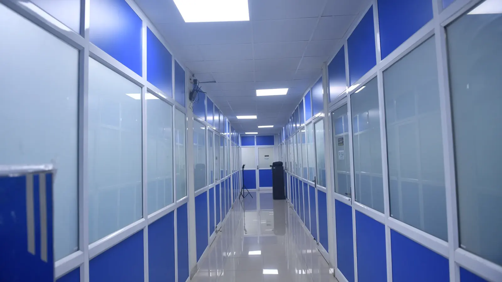 Blue-panel corridor through the quality assurance wing